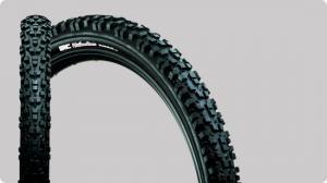 IRC Freedomcross Trailbear: A close-up view of a mountain bike tire, showcasing its textured tread pattern and branding against a neutral gray background.