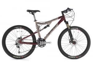 Ibex Asta Pro: A mountain bike with a maroon and silver frame, featuring dual suspension, disc brakes, and thick tires suitable for off-road riding. The bike is shown from the side.