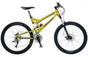 Mongoose Teocali Super: A bright yellow mountain bike with a dual suspension frame, featuring large black tires and a gear shifting mechanism. The bike is designed for off-road riding.