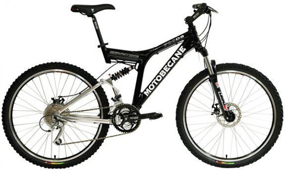 Motobecane 700DS: Mountain bike featuring a black and silver frame, with dual suspension, disc brakes, and knobby tires suitable for off-road riding. The bike is branded with the name "Motobecane" prominently displayed on the frame.
