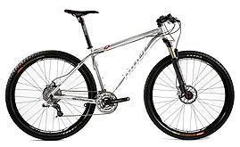 Niner Air 9: A silver mountain bike with a lightweight aluminum frame, front suspension, and disc brakes, showcasing wide tires suited for off-road terrain.