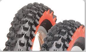 Panaracer Fire FR: Close-up view of two off-road motorcycle tires featuring aggressive tread patterns for enhanced grip and traction on rugged terrain. The tires have a distinct black rubber surface with bright red accents.