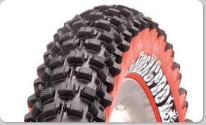 Panaracer Fire XC Pro: Close-up view of a motorcycle tire featuring deep treads for improved traction, with a red sidewall and distinctive branding.