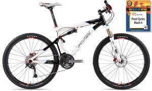 Pivot Mach 4: Mountain bike with a white and black frame, front suspension, and wide tires, next to a book titled "Pivot Cycles Mach 4."