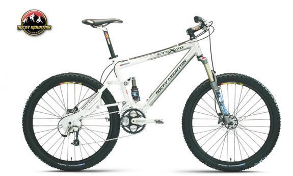 Rocky Mountain ETSX-70: A white mountain bike with a sleek design, featuring wide tires, a front suspension fork, and a prominently visible brand logo. The bike is positioned at an angle to showcase its frame and components, making it suitable for off-road riding.