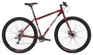 Salsa El Mariachi: A red mountain bike with a sturdy frame, large black tires, and disc brakes, positioned against a plain background. The bike features a comfortable saddle and a handlebar with brake controls.