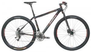 Salsa Mamasita: A sleek black mountain bike with a lightweight frame, equipped with front suspension, disc brakes, and wide tires suitable for off-road trails. The bike features gear shifters and a minimalistic design, highlighting its performance-oriented features.