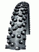 Schwalbe Ice Spiker: Close-up view of a motorcycle tire with a rugged tread pattern designed for enhanced grip on various terrains. The tire features pronounced knobs and spikes for off-road performance.