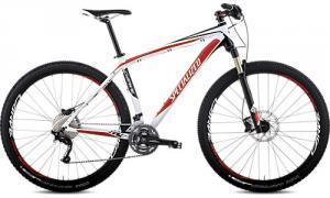 Specialized Carve Pro: A sleek white and red mountain bike with a lightweight frame, front suspension, and knobby tires, positioned against a plain background.