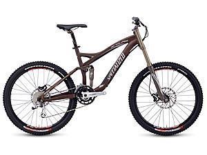 Specialized Enduro SL Expert: Mountain bike with a brown frame, front suspension, wide tires, and disc brakes, designed for off-road cycling.
