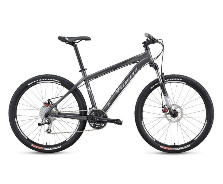 Specialized Rockhopper Comp Disc: A sleek gray mountain bike with wide tires, a sturdy frame, and disc brakes, positioned against a plain white background.