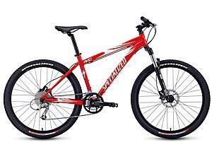 Specialized Rockhopper Disc: Red mountain bike with a lightweight frame, front suspension, and thick tires, designed for off-road cycling.