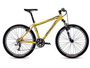 Specialized Stumpjumper: A vibrant yellow mountain bike with a lightweight frame, featuring front suspension, knobby tires, and a multi-gear system, positioned against a neutral background.