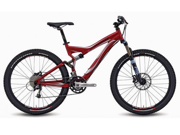 Specialized Stumpjumper FSR Elite: A red mountain bike with a sleek frame, featuring wide tires suited for off-road terrain, a front suspension fork, and disc brakes. The bike is positioned on a plain background, highlighting its design and components.
