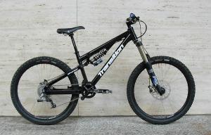 Transition Bottlerocket: A black mountain bike with a sturdy frame, featuring fat tires and a suspension system, positioned against a neutral background.