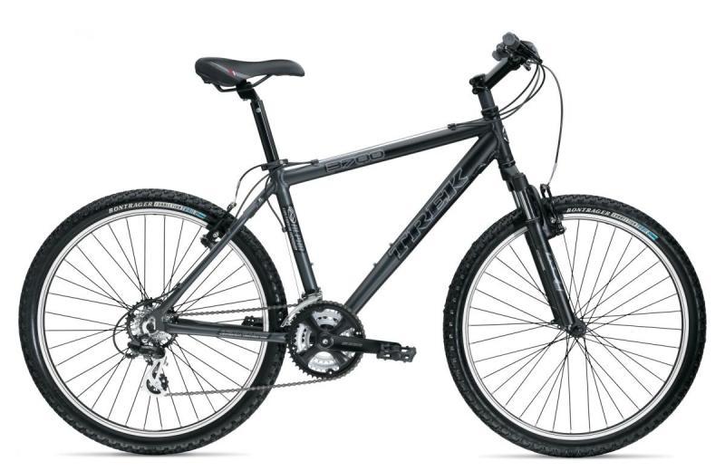 A black Trek 3700 mountain bike is displayed on a white background, showcasing its sturdy frame, front suspension, and knobby tires designed for off-road terrain. The bike features a comfortable saddle and various gears, emphasizing its suitability for outdoor cycling adventures.
