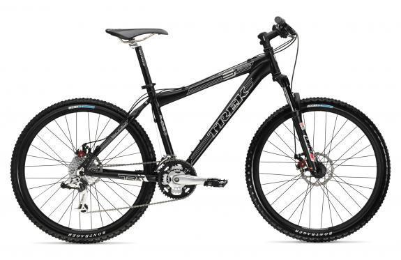 Trek 6000: A black mountain bike with a sturdy frame and thick tires, featuring disc brakes and a gear system, positioned on a white background.