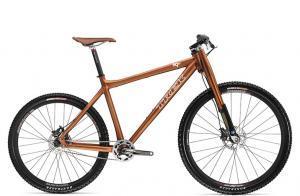 Trek 69er: Alt tag: "An orange mountain bike with thick tires and a sleek frame, featuring a sporty design and front suspension."