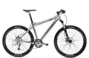 Trek 8000: A modern silver mountain bike with disc brakes, a lightweight aluminum frame, and knobby tires, standing on a white background.