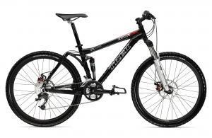 Trek Fuel EX 5.5: A black mountain bike with a sturdy frame, wide tires, and front suspension, positioned on a white background.