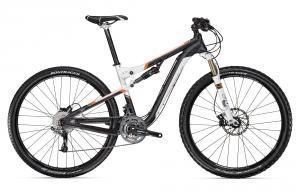 A modern mountain bike featuring a black and orange design, with dual suspension, knobby tires, and disc brakes. The bike is positioned on a plain background, showcasing its lightweight frame and components.