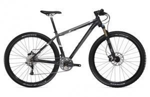 Trek Paragon: Mountain bike with a sleek black frame, front suspension, and disc brakes, positioned on a white background.