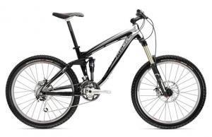 Trek Remedy 7: A black and silver mountain bike with a dual suspension design, featuring wide tires, disc brakes, and a sleek frame suitable for off-road trails.