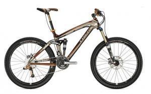 Trek Remedy 9.9: A modern mountain bike with a bronze and silver frame, equipped with wide tires, front suspension, and a geared drivetrain, positioned against a plain background.