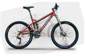 Turner 5.Spot: A red mountain bike with a sturdy frame, suspension fork, and wide tires, positioned against a light gray background.