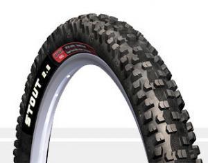 WTB Stout: A close-up image of a mountain bike tire with a tread pattern designed for off-road terrain. The tire features the text "STOUT 2.3" on its sidewall, indicating the model.