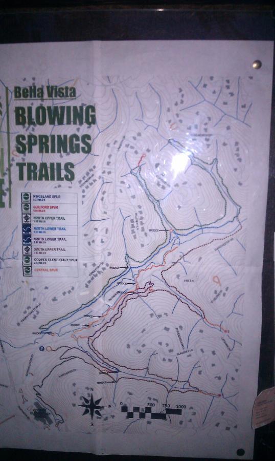 Map of Blowing Springs Trails in Bella Vista, showing various hiking and biking trails, trail names, and elevation contours. Includes a legend for different trail types and features. Blowing Springs mountain bike trail.