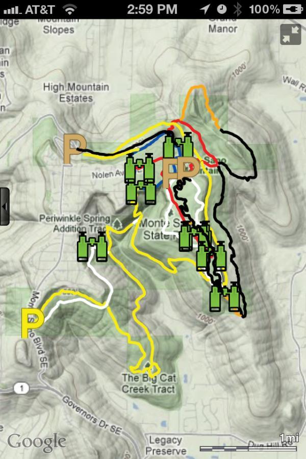 Map of a trail system near Mount St. Helens, featuring paths marked in various colors (red, yellow, blue, and black) with parking locations indicated by large green icons. The map delineates different trails and areas of interest, showing elevation changes and surrounding landmarks, including nearby neighborhoods and natural features. Monte Sano State Park &amp; Land Trust mountain bike trail.
