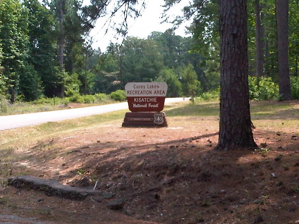 Sign marking the entrance to Caney Lakes Recreation Area in Kisatchie National Forest, surrounded by trees and natural landscape. Caney Lakes Trail mountain bike trail.