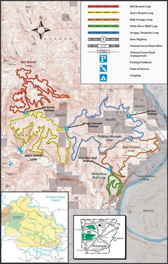 Map of trails in the Sylamore Ranger District, Arkansas, featuring routes such as Bad Branch Loop, Jack's Branch Loop, Bald Scrappy Loop, White River Bluff Loop, and Scrappy Mountain Loop. The map includes trailheads, parking areas, and points of interest, with various colored lines indicating different trails and road types. Insets show detailed areas of the district and surrounding regions. Syllamo Trails mountain bike trail.