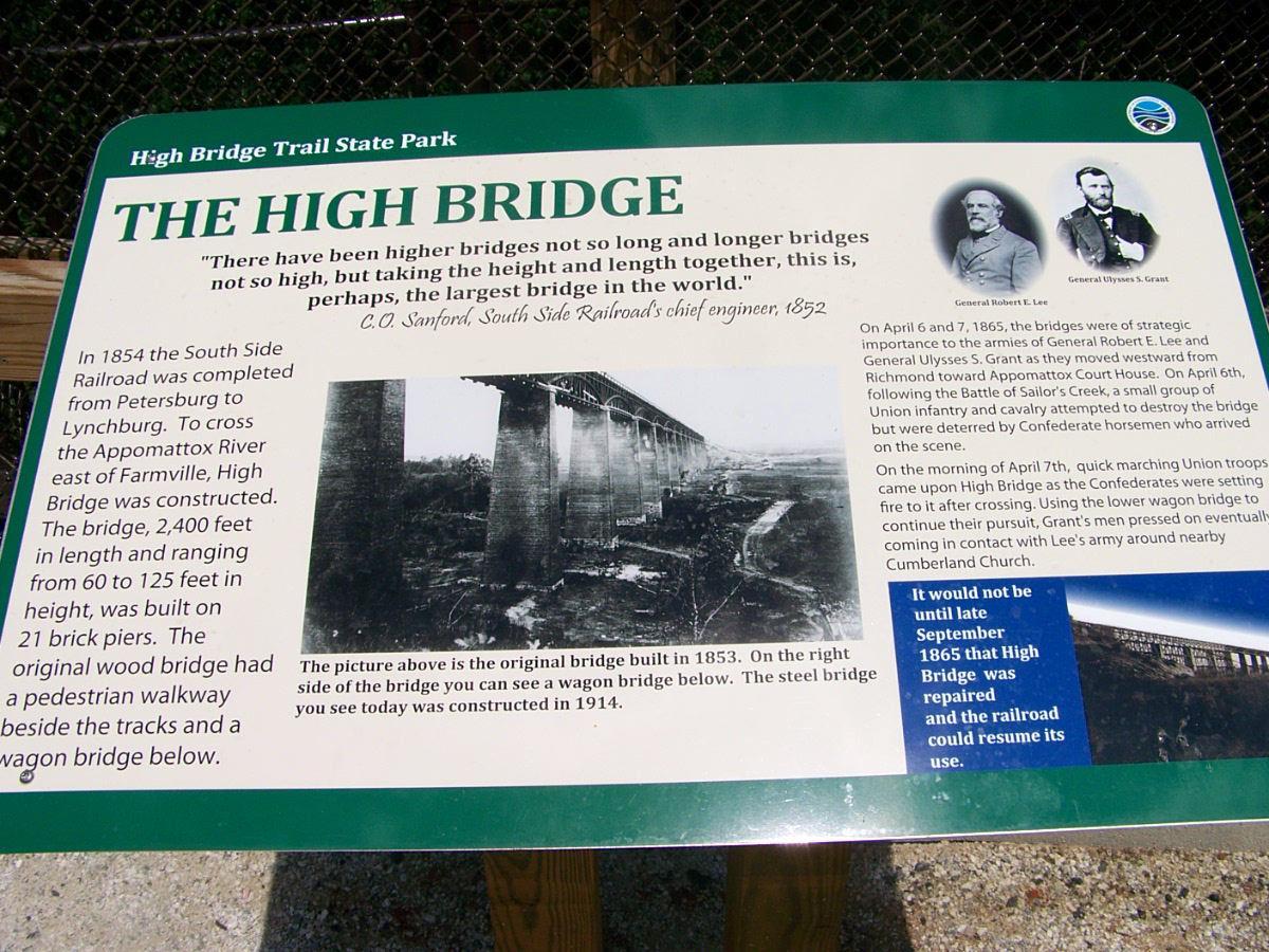 Information sign about the High Bridge at High Bridge Trail State Park. The sign includes historical details about the bridge's construction, its significance during the Civil War, and mentions key figures such as General Robert E. Lee and General Ulysses S. Grant. A photo of the original bridge from 1853 is included, alongside descriptions of its dimensions and historical context. High Bridge Trail mountain bike trail.