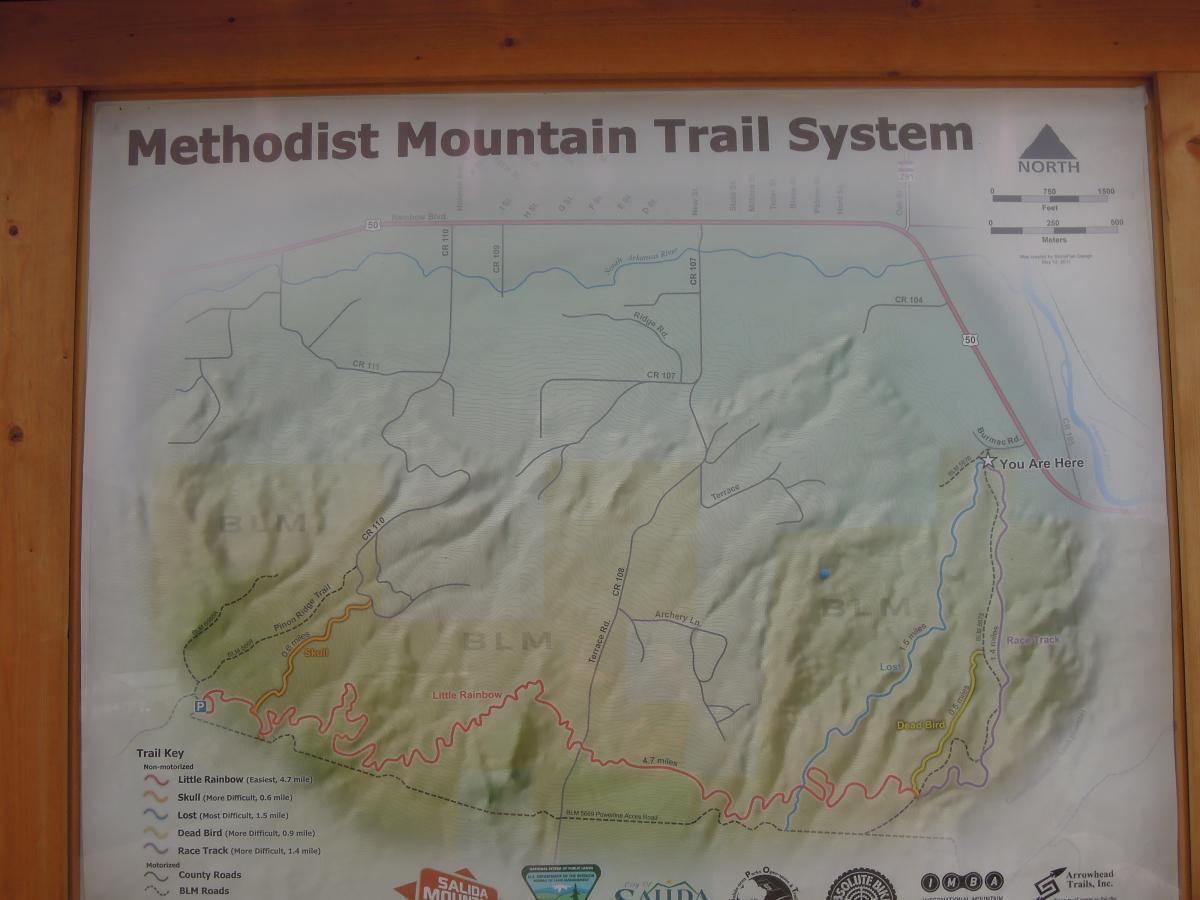 Map of the Methodist Mountain Trail System, featuring various trails marked by difficulty levels (e.g., Little Rainbow, Skull, Lost, Dead Bird, Race Track) and key locations. The map includes directional indicators, a "You Are Here" marker, and highlights nearby roads and BLM (Bureau of Land Management) areas. Skull mountain bike trail.