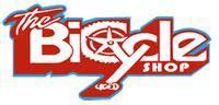 Logo of "The Bicycle Shop," featuring stylized text with a bicycle wheel and pedal elements incorporated into the design. The colors are red and white, with a playful font.