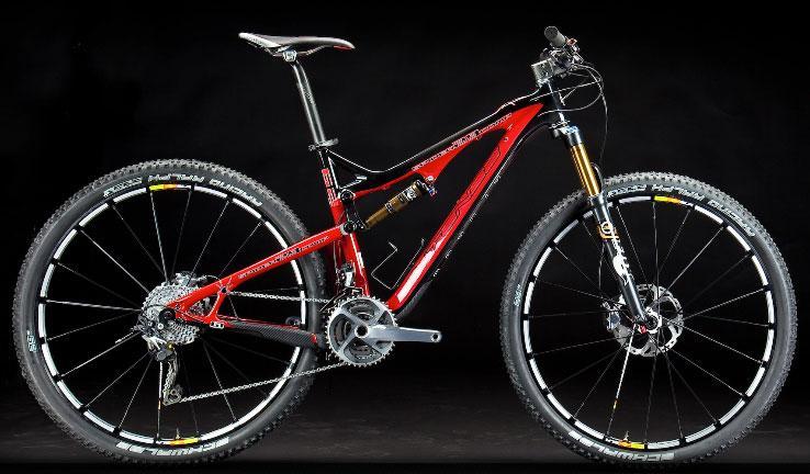 Intense Spider 29: A high-performance red mountain bike with a sleek design, featuring dual suspension, thick tires, and a modern frame. The bike is set against a black background, highlighting its components including the handlebars, gear system, and suspension components.