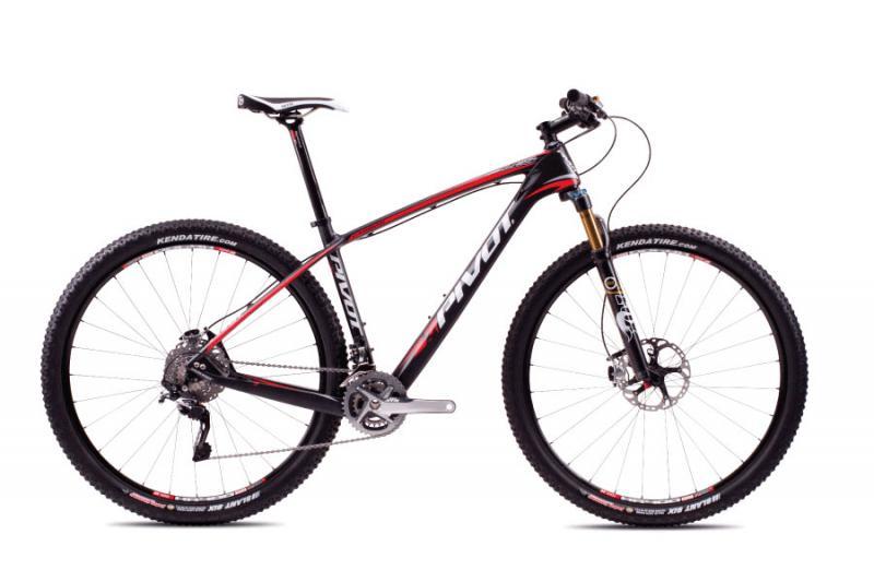 Pivot Les: A black and red mountain bike with a lightweight carbon frame and prominent branding, featuring thick tires designed for rugged terrain, a front suspension fork, and a modern gear system.