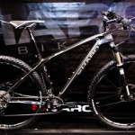 A sleek black mountain bike with green accents, featuring a lightweight frame and thick tires, displayed against a dark backdrop with the brand name "Haro" prominently visible. The bike showcases modern design elements suited for off-road cycling.