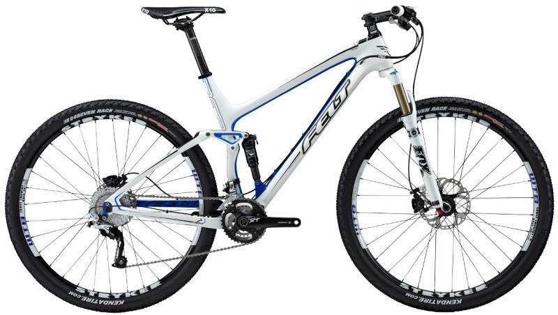 Felt Edict Nine: Image of a high-performance mountain bike featuring a sleek white and blue design. The bike includes prominent features such as front suspension, disc brakes, and wide tires suitable for off-road terrain, showcasing its lightweight frame and advanced components for optimal riding performance.
