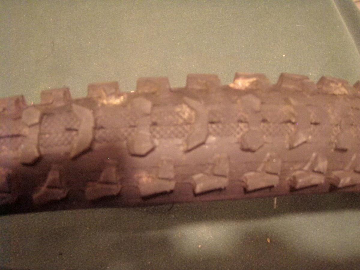Kenda Klaw: Close-up image of a used bicycle tire tread, showing worn rubber and distinct patterns on the surface.