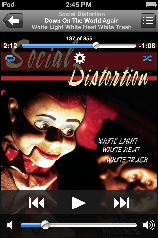 Rhapsody International Rhapsody: Album cover for "White Light White Heat White Trash" by Social Distortion, featuring a close-up of a ventriloquist dummy with a painted face and expressive eyes. The background includes the album title and song information displayed on a digital music player interface. The overall color scheme has dark tones with bright accents.