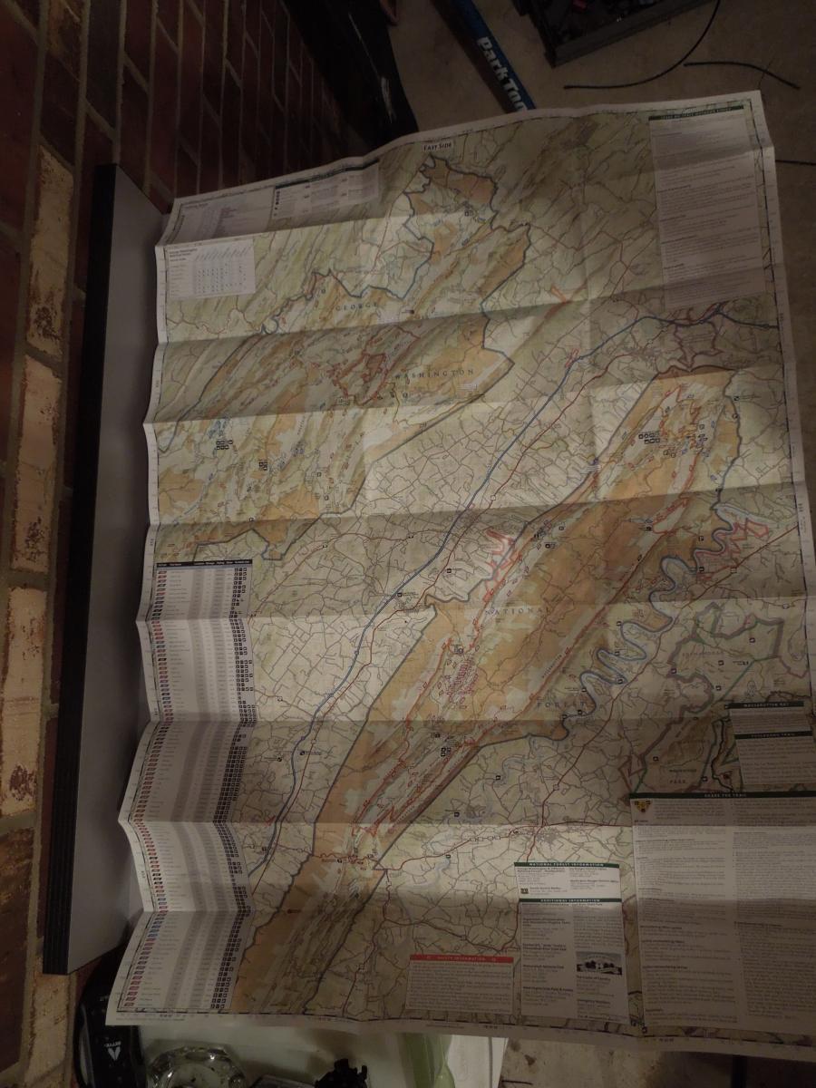 Trails Illustrated National Geographic Massanuten and Great North Mountain: A folded topographic map displaying geographical features, roads, and points of interest. The map is laid out on a flat surface, with details including elevation lines and color-coded terrain. Some legend and informational text are visible in the margins.
