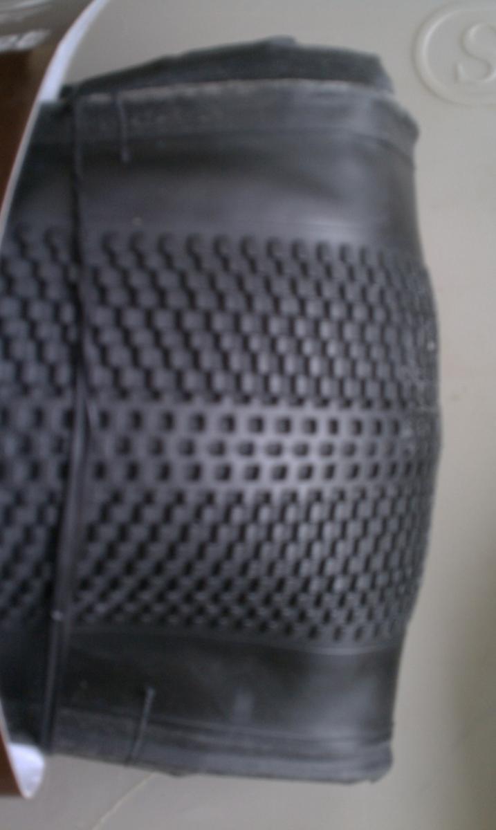 ITS Micro Knobby: Close-up image of a black rubber shoe sole with a textured, patterned surface. The background is a neutral color, providing contrast to the shoe sole.