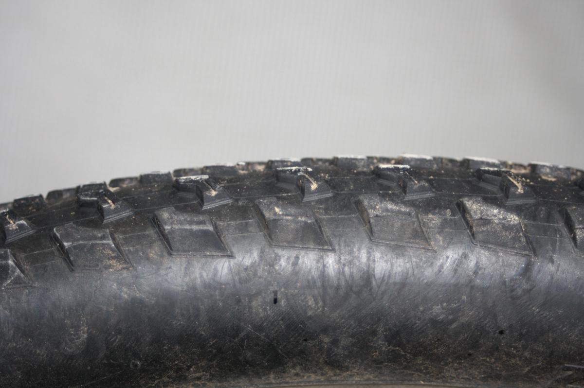 Specialized Fast Trak: Close-up view of a textured black tire, showcasing its tread pattern and surface details, against a neutral background.