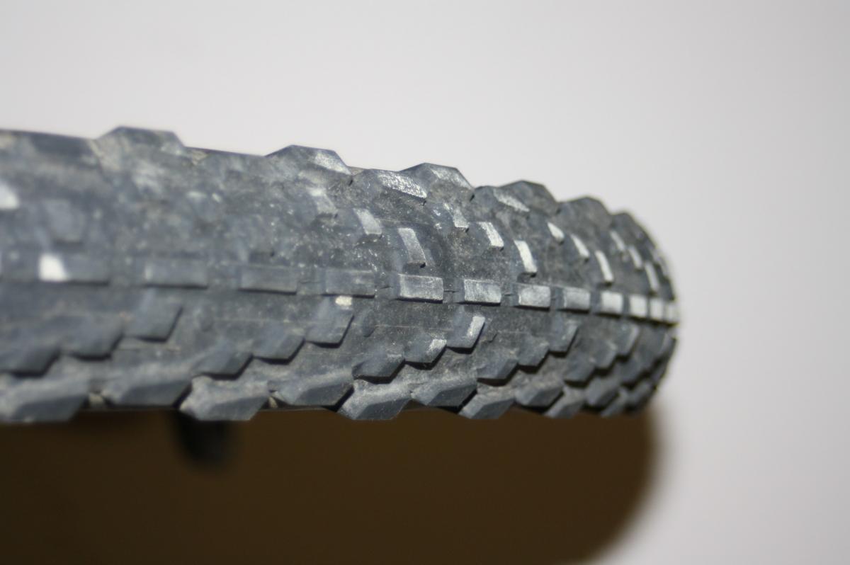 WTB Mutano Raptor: Close-up view of a bicycle tire showcasing its textured tread pattern, designed for traction on various surfaces. The tire appears slightly worn, indicating use, with a neutral background.