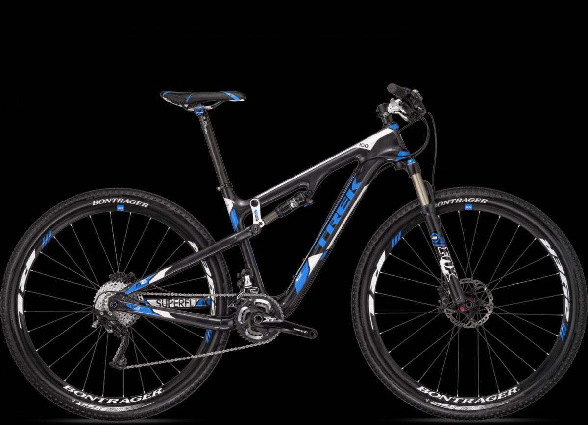Trek Superfly 100 Elite carbon: A sleek black and blue Trek mountain bike with a lightweight frame, front suspension fork, and knobby tires, displayed against a black background. Features include Bontrager wheels and Shimano XT components for enhanced performance.