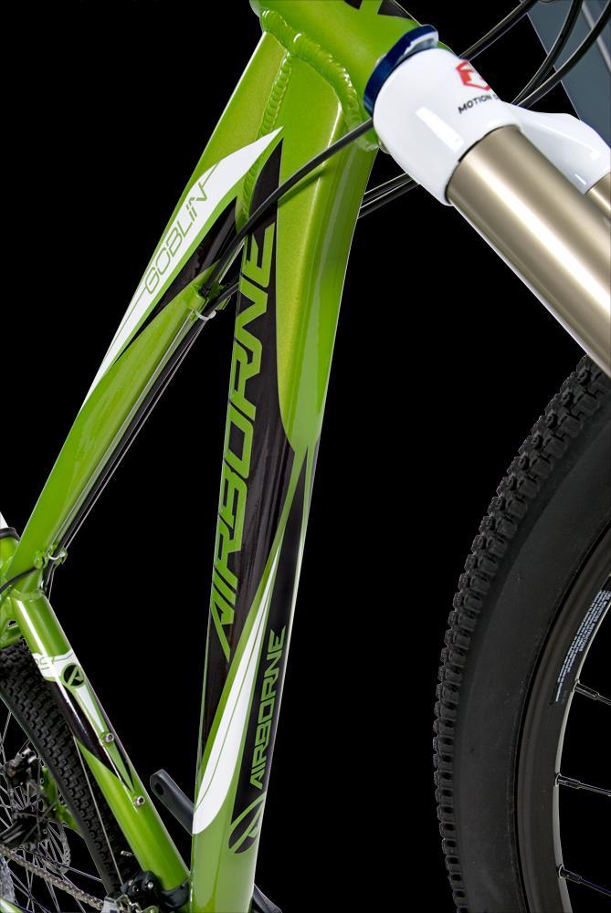 Airborne Goblin: close-up of a vibrant green mountain bike frame with the name "Airborne" prominently displayed, featuring a suspension fork and textured tire, set against a black background.