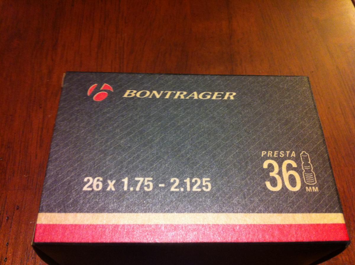Bontrager Premium Tube: Box of Bontrager bicycle inner tube, labeled for size 26 x 1.75 - 2.125, featuring a 36 mm Presta valve. The box has a dark background with the Bontrager logo and design elements.